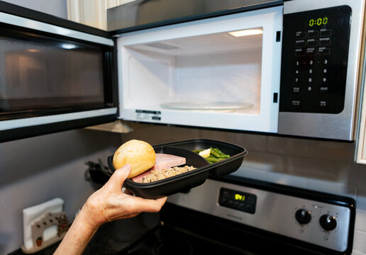 Meal: Woman Puts Delivered Meal Into Microwave To Warm