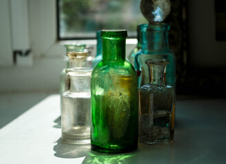 
Old glass bottles stand on the windowsill
