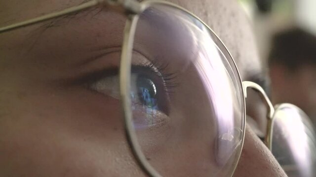 Acercamiento a ojo de mujer viendo una pantalla a trav&eacute;s de sus lentes 