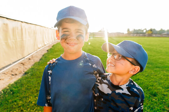 Two boys in their baseball uniforms.