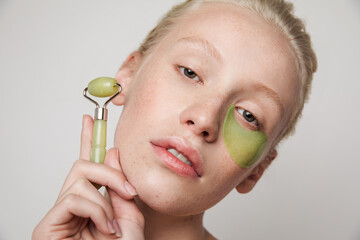 Girl with jade roller and eye patch