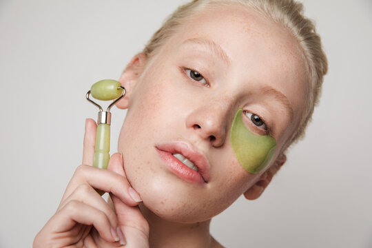 Girl with jade roller and eye patch