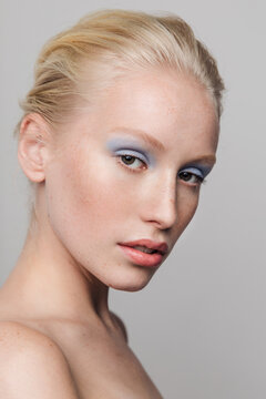 Young freckled girl with blue eyeshadows