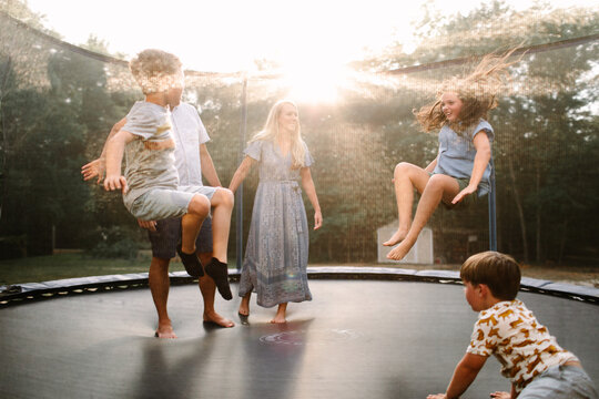 Family Jumping On Trampoline Together