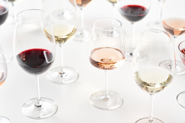 Assorted wine in glasses on white table