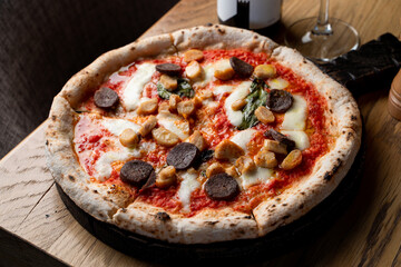 Hot and appetizing sausage pizza with melted cheese, soft dark light in a fancy restaurant, menu photography