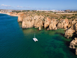 Naklejka premium sailing catamaran boat on the beach in Portugal, aerial landscape 