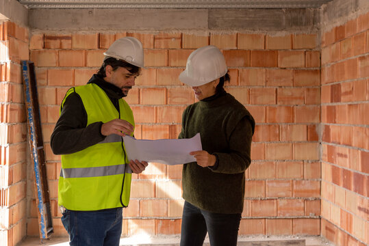 Builder and client discussing draft of new house