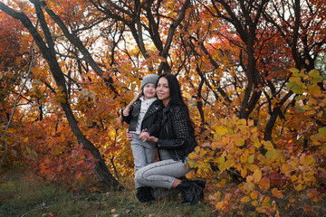 happy mother and child daughter walk in the autumn