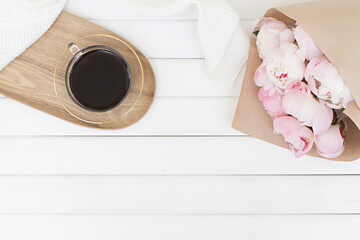 Spring composition with pink tulips on wooden background. Flat lay floral frame and white textile. Border top view.
