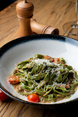 Vegetarian tagliatelle in an italian restaurant, wooden table, menu photography set