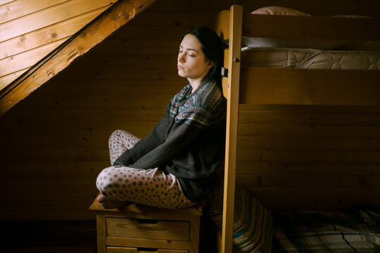 girl in pajamas sitting on the bedside table
