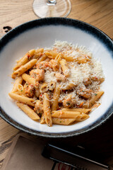 Ground beef pasta with a big pile of grated parmesan, rustic italian restaurant, vintage atmosphere
