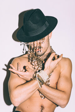 a man  with golden jewelry and a black hat