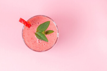 Strawberry milkshake with mint on a pink background. Healthy eating for breakfast and snacks