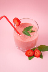Strawberry milkshake with mint on a pink background. Healthy eating for breakfast and snacks