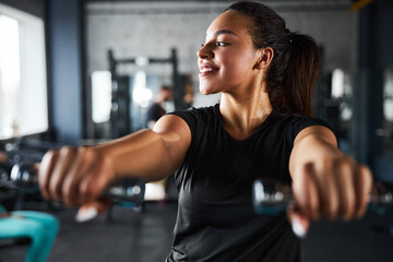 Cheerful young woman doing upperbody workout indoors