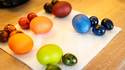 Freshly painted colorful easter chicken and quail eggs lie in the kitchen