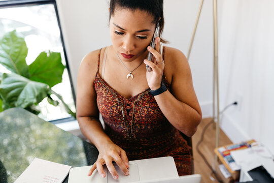 An African American woman working from her home office. 