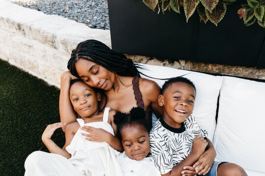 An African American mother with her children sitting on her lap. 