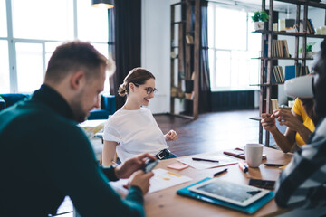 Young diverse colleagues discussing project in modern workspace