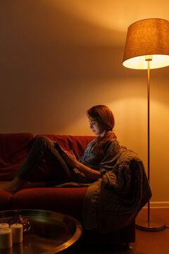 Woman using tablet in living room in evening