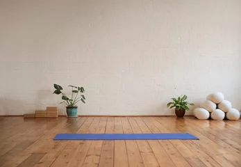 Wandcirkels Yogaschool Yoga mat lying on wood floor in a yoga studio  © merla