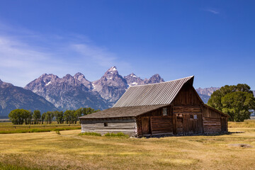 Fototapeta na wymiar Wooden barn with Grand Teton mountain range in background