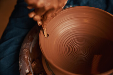 Unrecognized craft woman using special tool while shaping pattern into in tableware