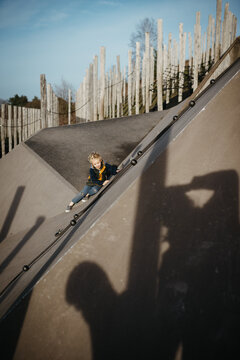 Blond boy playing on a concrete playground outdoors