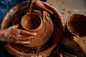 Unrecognized female artisan shaping ceramic bowl in pottery workshop