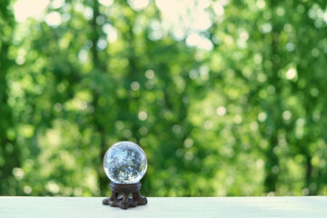 magic clear quartz ball on green natural background. beautiful crystal ball for meditation,...
