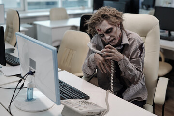 Zombie man with grey greesepaint all over body going to make telephone call