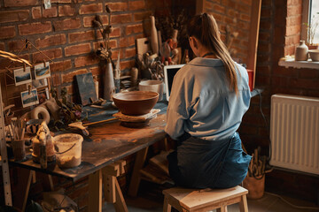 Charming young craft lady at the work process in art workshop