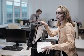 Young dead female making paper copies by xerox machine