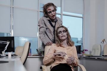 Two dead or zombie managers working in office environment