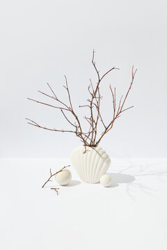 Ceramic vase in shape of shell with twigs