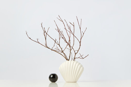 Ceramic vase in shape of shell with twigs