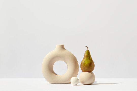 Still life with ceramic vase and pear