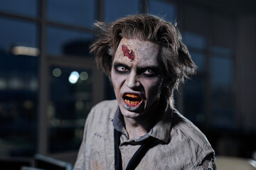Scary zombie businessman with spooky facial expression looking at you
