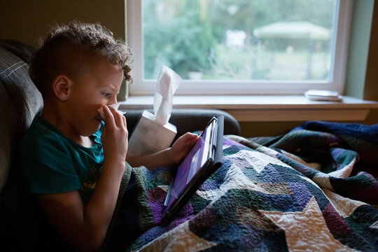 Sick child on couch with tissues