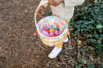 Close up of a Young Boy's Colorful Easter Basket Filled with Colorful Easter Eggs