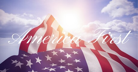 Composition of text america first in white over american flag billowing in sunny cloudy blue sky - obrazy, fototapety, plakaty