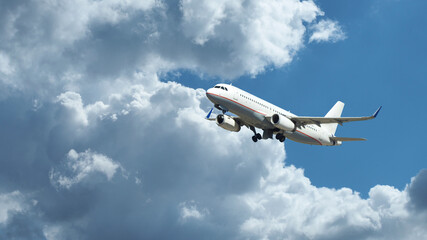 Naklejka na ściany i meble Zoom photo of passenger plane flying above deep blue cloudy sky