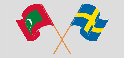 Crossed and waving flags of Maldives and Sweden