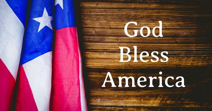 Composition of text god bless america with american flag on wood background