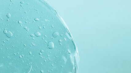 Background from cosmetic gel with bubbles,dripping down.Pastel blue color,copy space for text or design.Top view,antibacterial liquid surface.Good as background or mockup.Large banner.