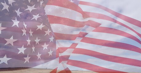 Obraz premium Composition of billowing american flag over cloudy blue sky