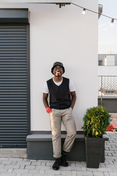 Relaxed African American guy leaning on wall