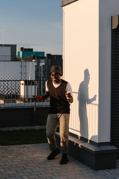Cheerful black guy dancing on rooftop